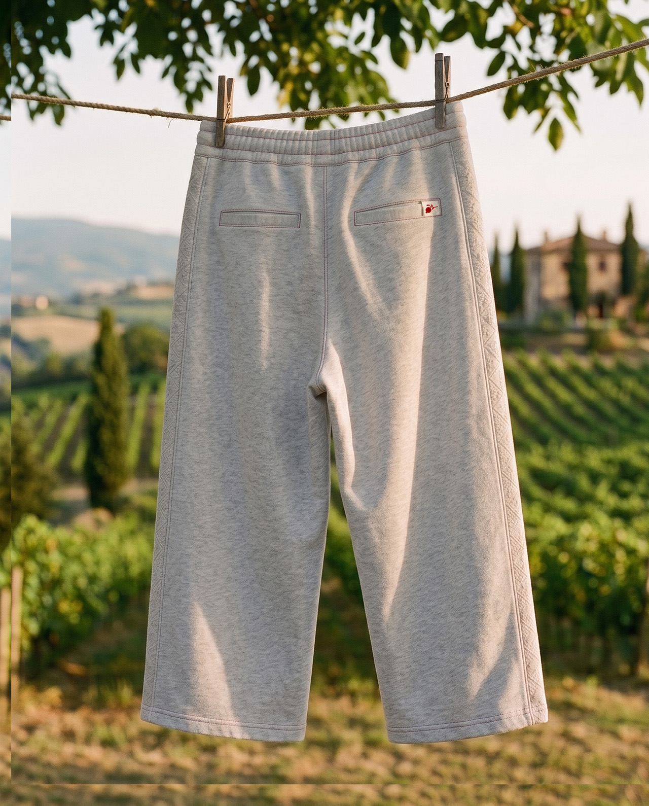 Back of the Mersyde heather-grey wide-leg joggers, hung on a line in the countryside