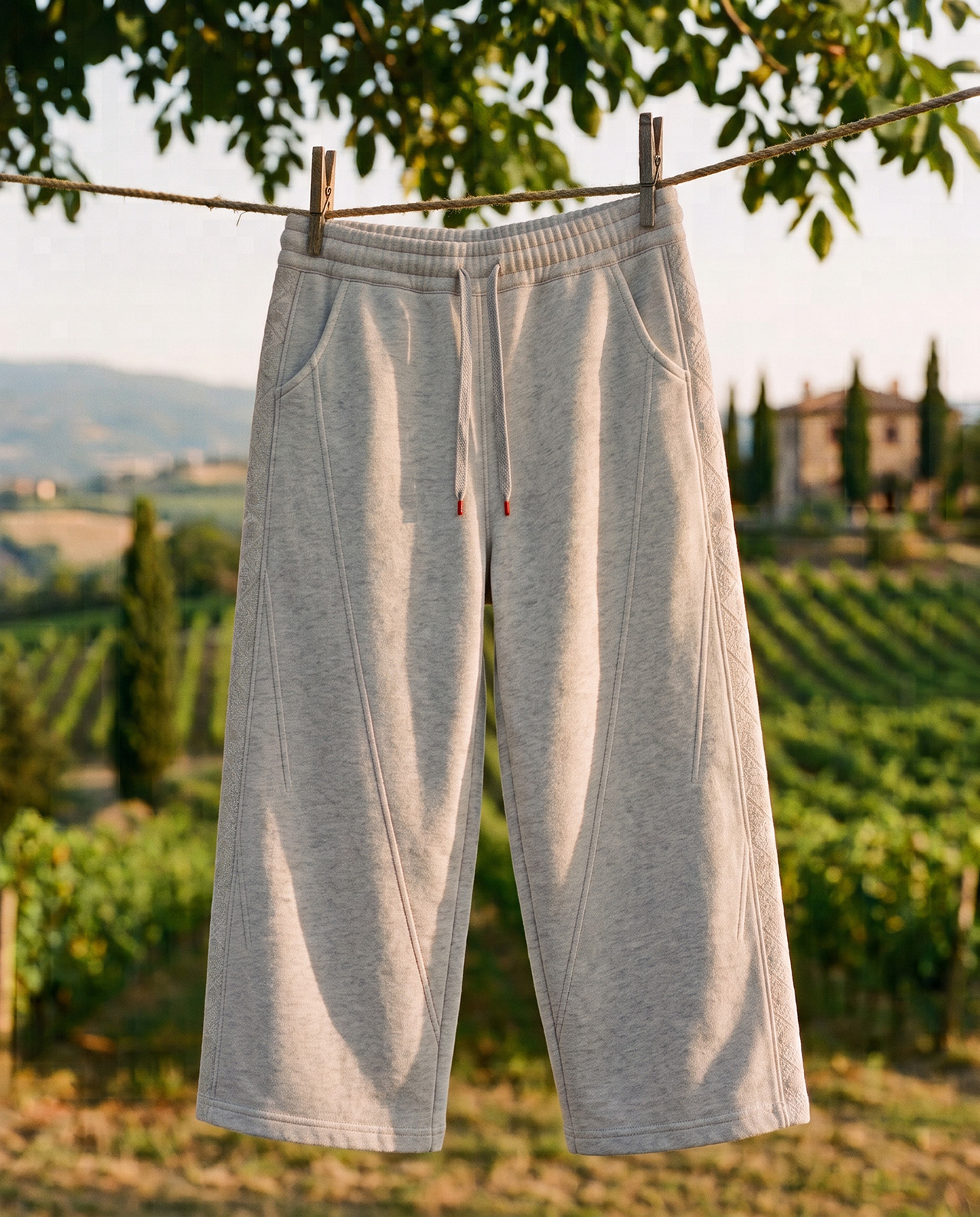 Mersyde heather-grey wide-leg joggers with a drawstring waist, front view, hung over a vineyard